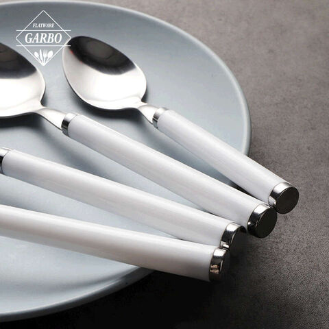 stainless steel spoon with white plastic handle for dinner