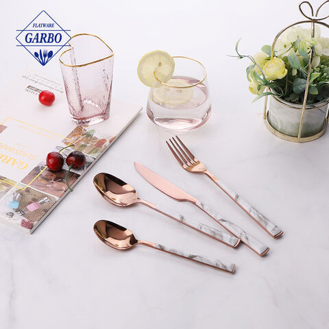 Roségoldfarbenes Besteckset mit Geschirr mit Kunststoffgriffen im ABS-Marmor-Design.