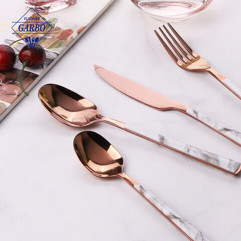 Roségoldfarbenes Besteckset mit Geschirr mit Kunststoffgriffen im ABS-Marmor-Design.