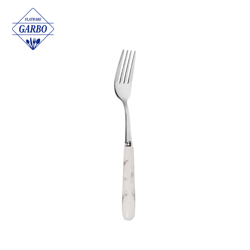 价格便宜的不锈钢餐叉，带优雅的白色陶瓷手柄